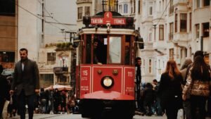 People Walking Next to the Red Tram on Istiklal Street