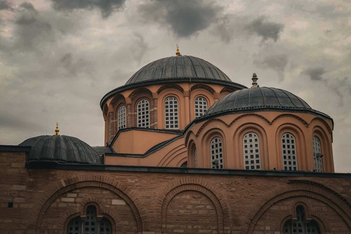 Byzantine domed architecture of a historic church against a cloudy sky, showcasing classic design.