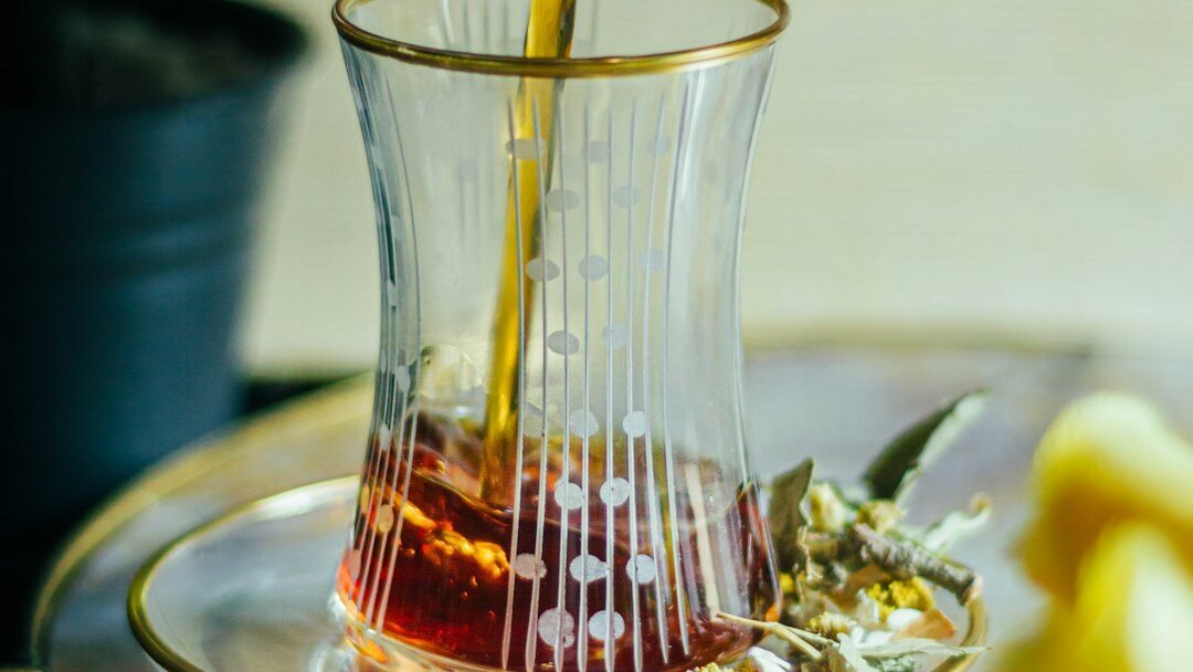 Turkish Tea - Health Benefits of Drinking Turkish Chai a pitcher pouring tea into a glass cup