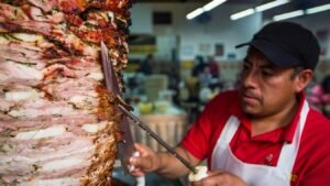 man in red and white polo shirt holding stainless steel fork