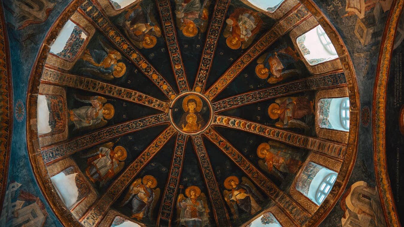 Intricate Byzantine mosaics depicting Christian icons on a historical domed ceiling.
