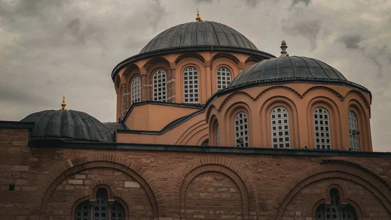 Byzantine domed architecture of a historic church against a cloudy sky, showcasing classic design.