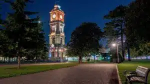 Illuminated Dolmabahçe Clock Tower at night in a tranquil park setting, Istanbul
