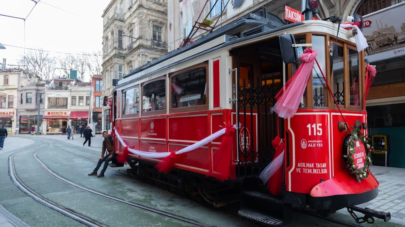 a red trolley car with a christmas wreath on the front