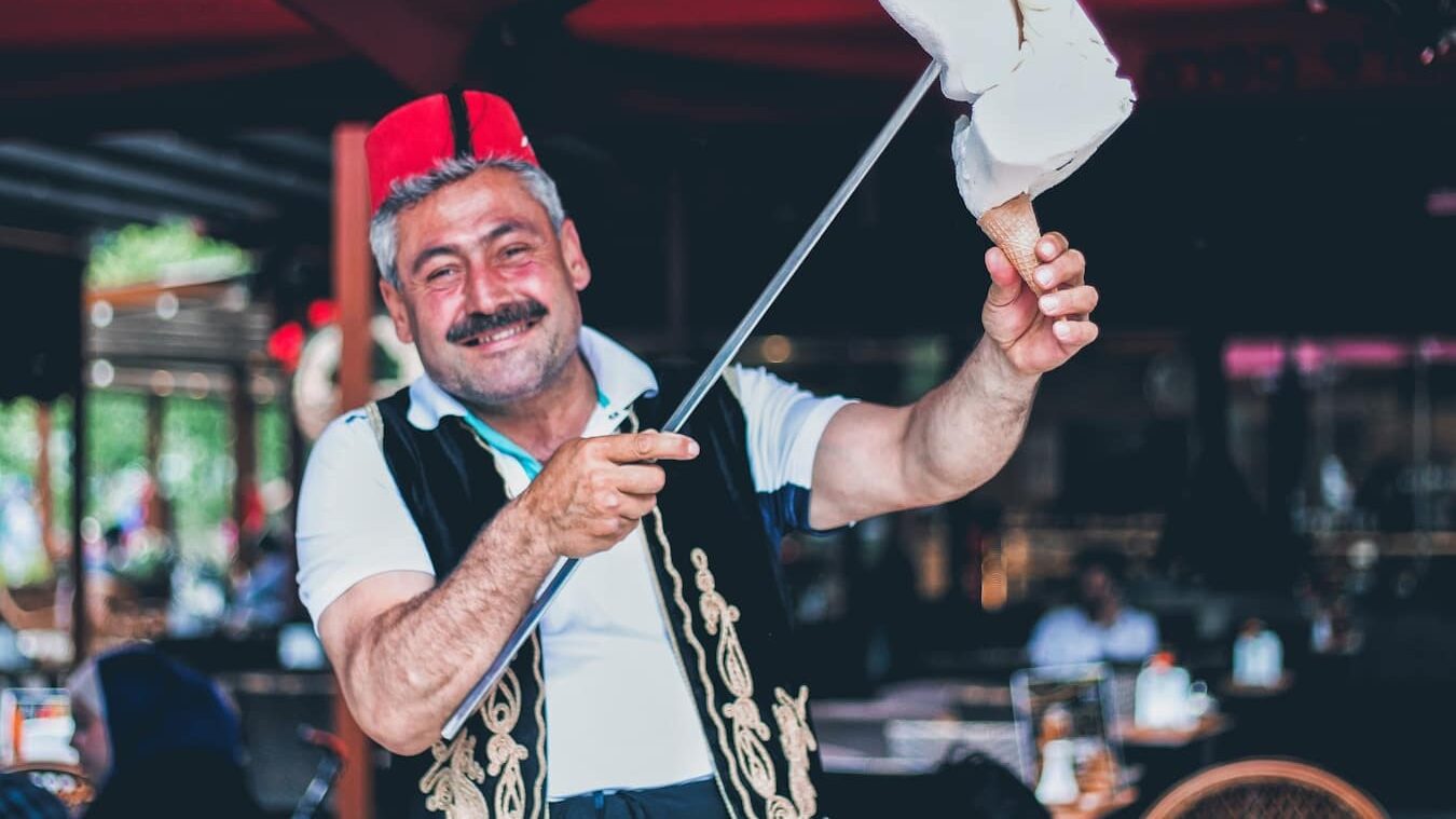 man smiling and holding stick with ice cream on cone