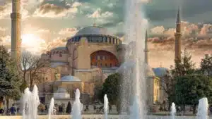 fountain in front of brown concrete building under cloudy sky during daytime
