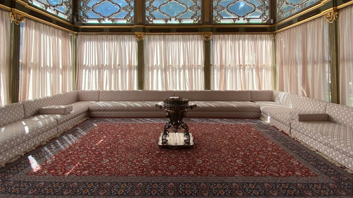 Topkapi Palace Museum - a room with a red carpet and a large chandelier