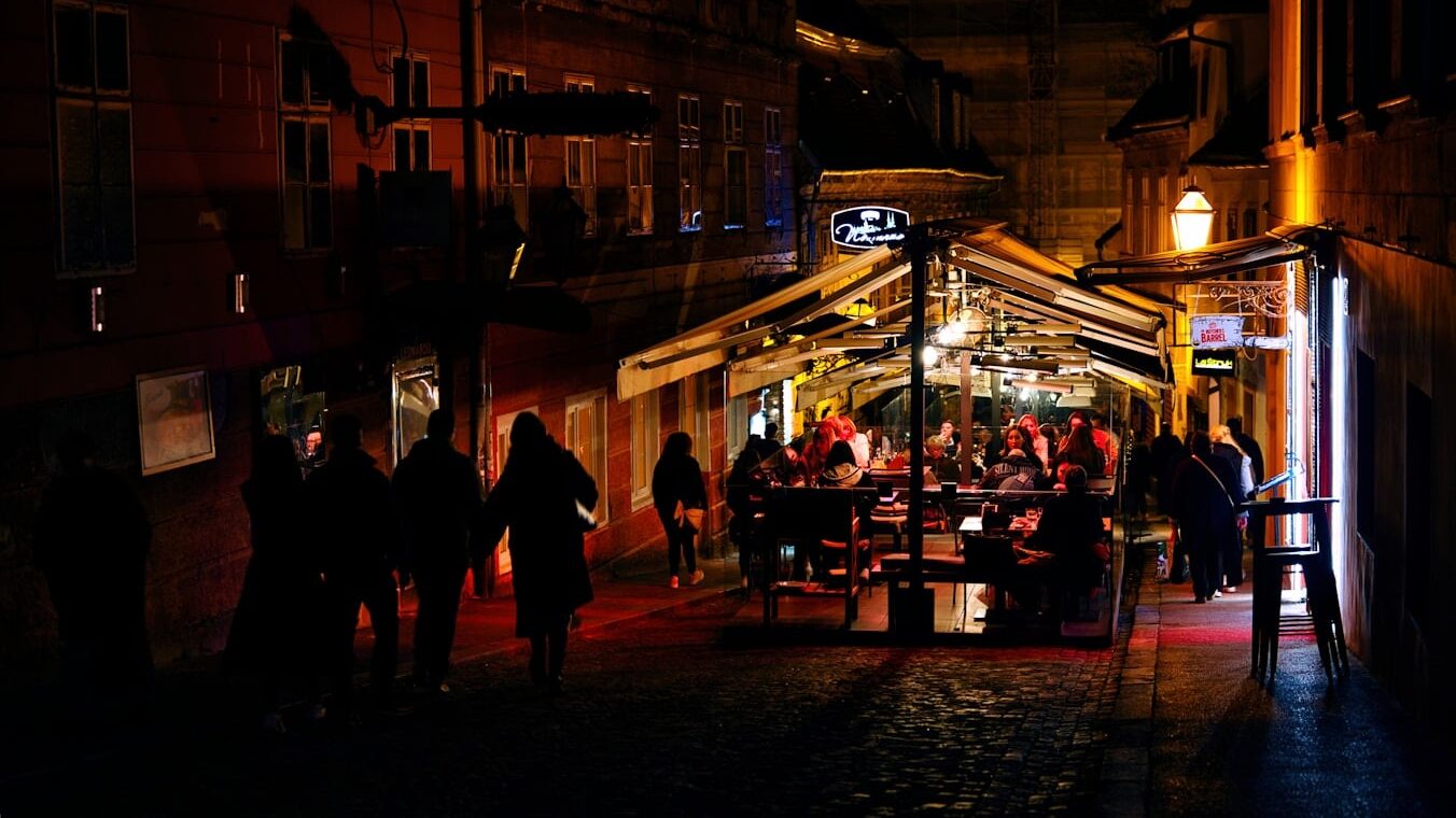 People dine at an outdoor restaurant at night.