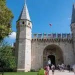 a group of people walking outside of a castle with Topkapı Palace in the background