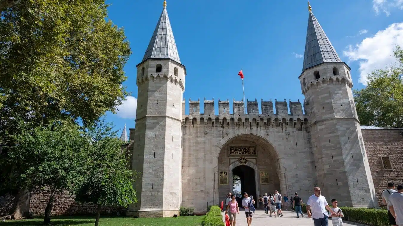 a group of people walking outside of a castle with Topkapı Palace in the background