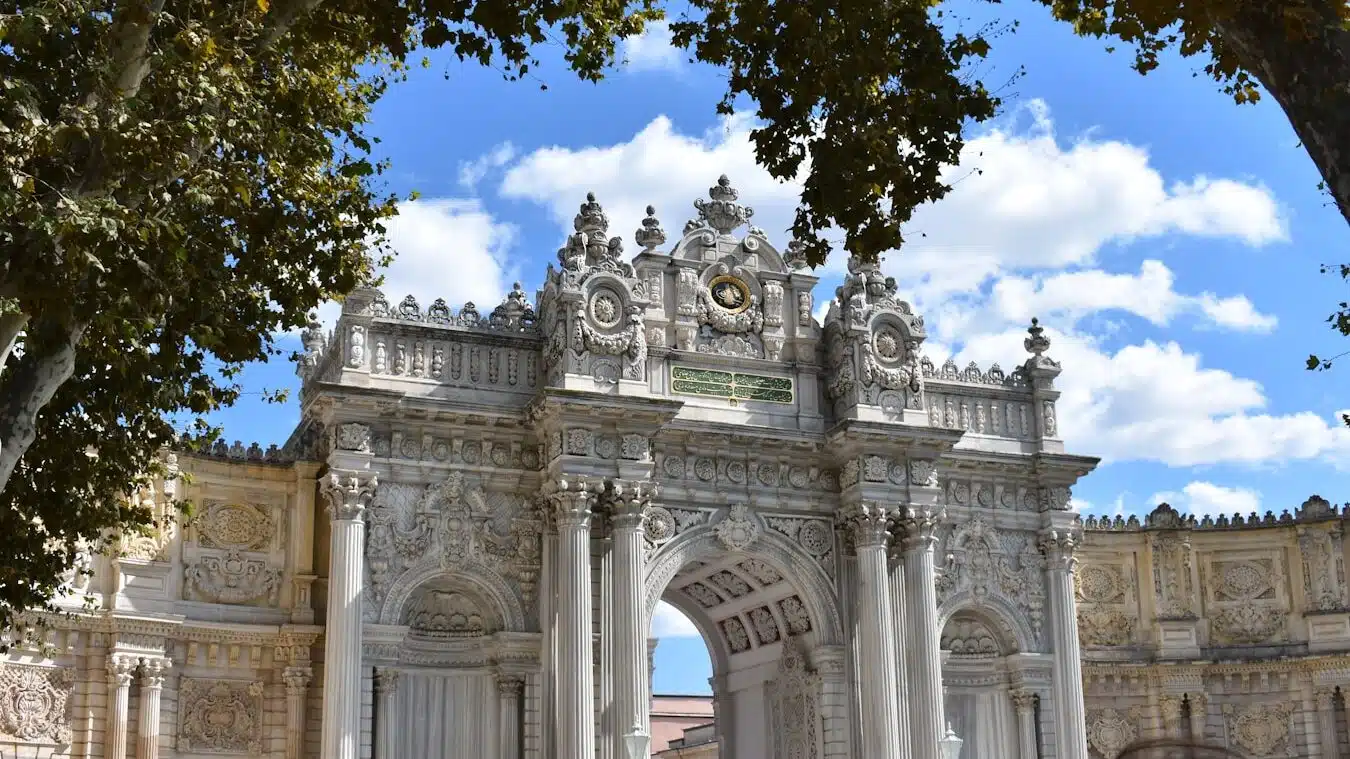 a large white arch with a clock on top of it