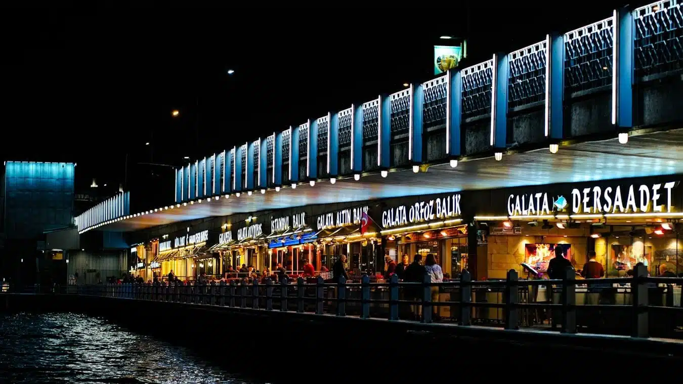 a group of people standing outside of a restaurant next to a body of water Eminönü Karaköy