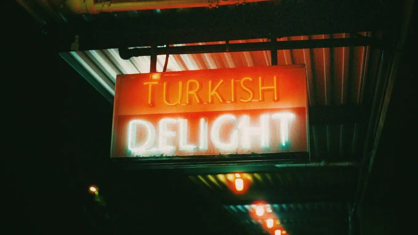 a neon sign hanging from the side of a building