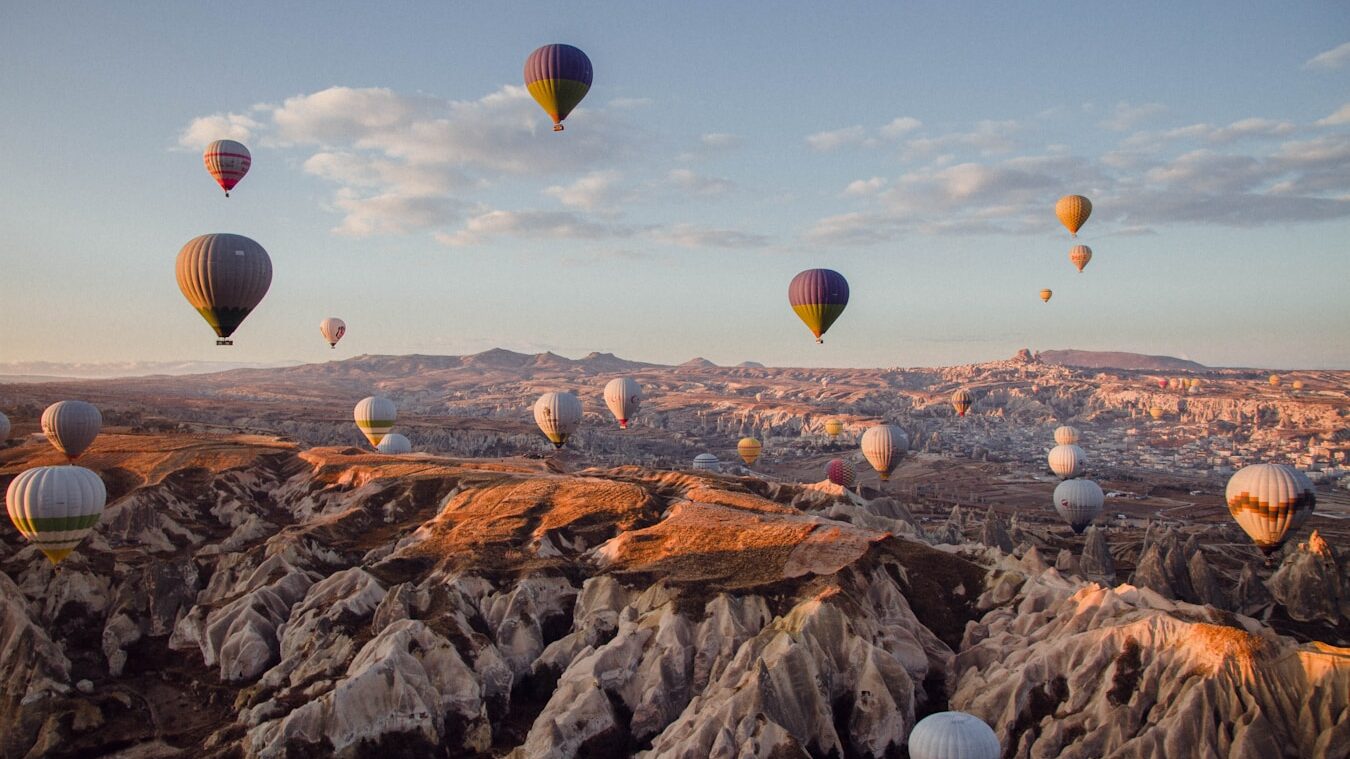 Unforgettable Things to Do in Cappadocia hot air balloons flying over the mountains during daytime