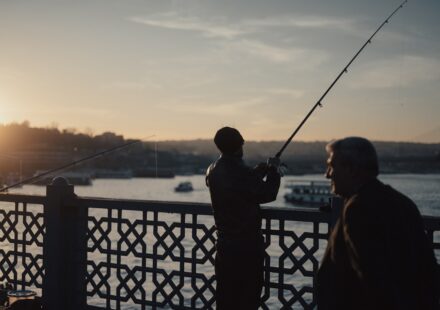 A couple of men standing next to each other on a bridge