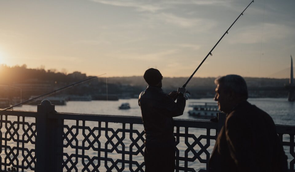 A couple of men standing next to each other on a bridge