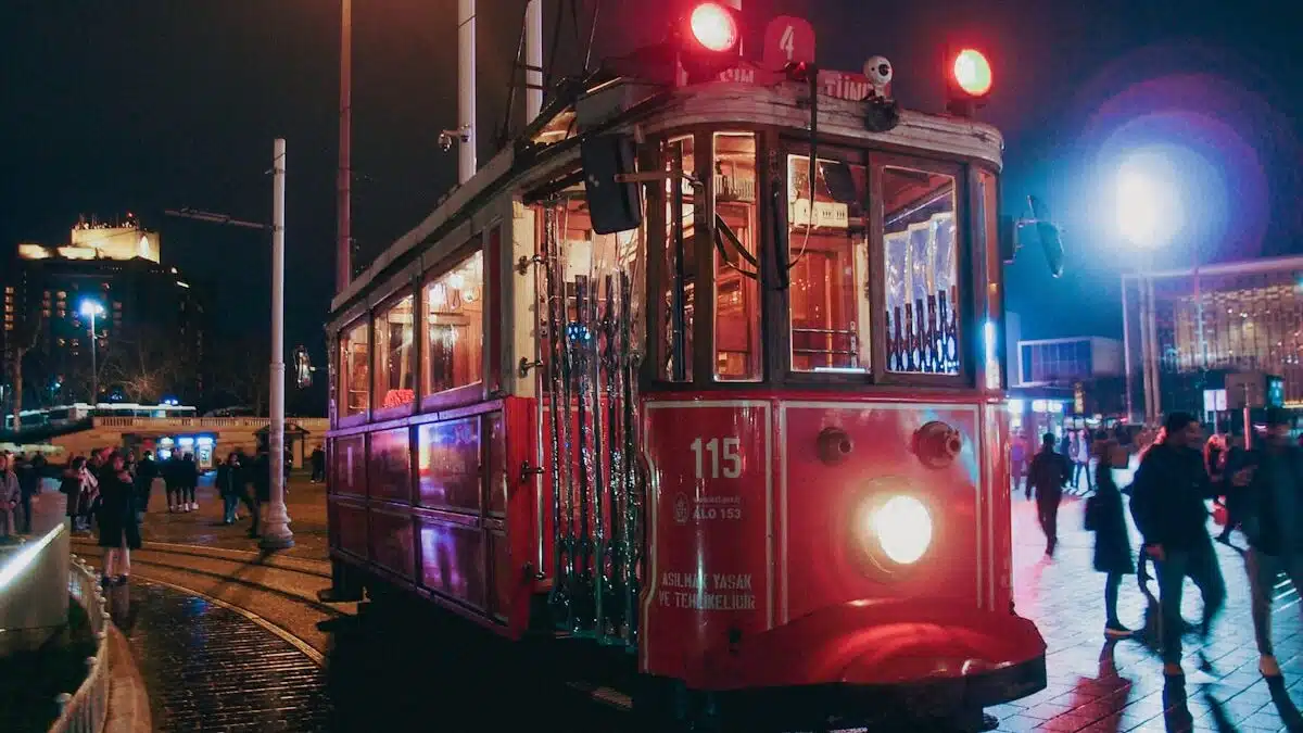 a red trolley car traveling down a street at night