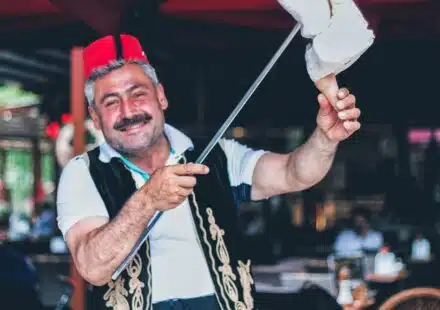man smiling and holding stick with ice cream on cone