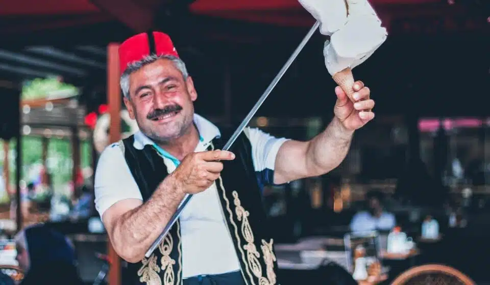 man smiling and holding stick with ice cream on cone