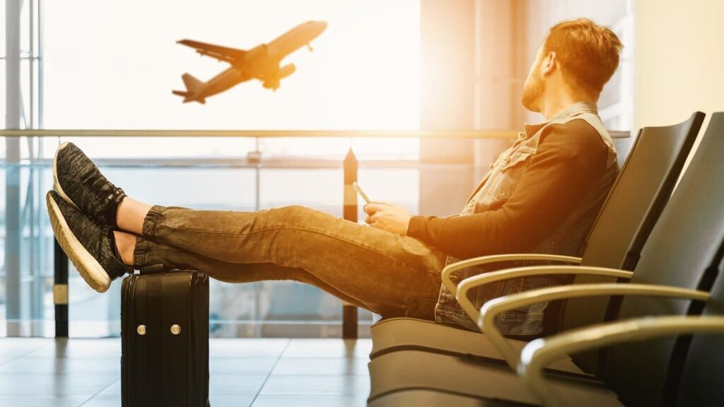 Istanbul Visa Guide: Do You Need a Visa for Istanbul? man sitting on gang chair with feet on luggage looking at airplane