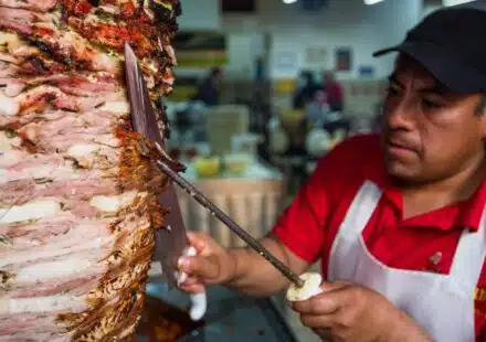 man in red and white polo shirt holding stainless steel fork