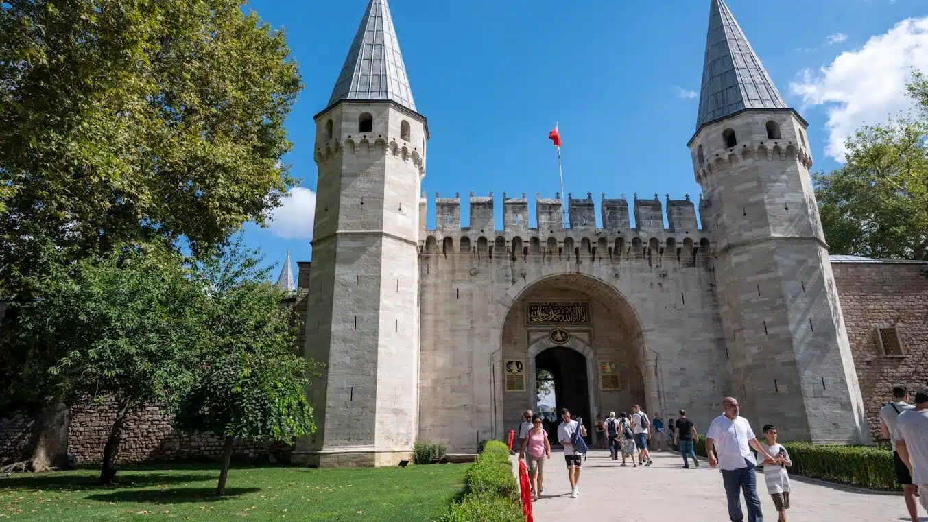 a group of people walking outside of a castle with Topkapı Palace in the background